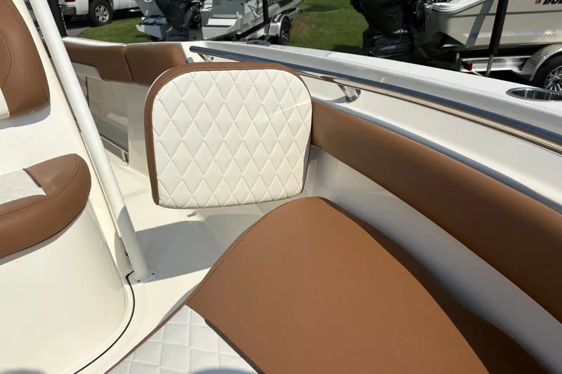 Slide: The Image of 2027 Pioneer 202 Islander boat interior with brown and white diamond-stitched seating. - 31