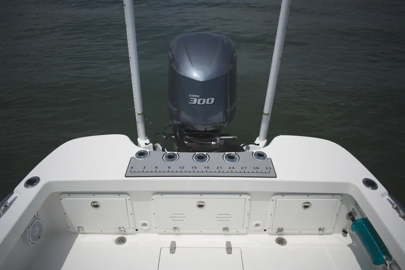 Slide: The Image of 2020 BlackJack 256 Coastal boat with Yamaha 300 engine, featuring rod holders and storage compartments. - 22