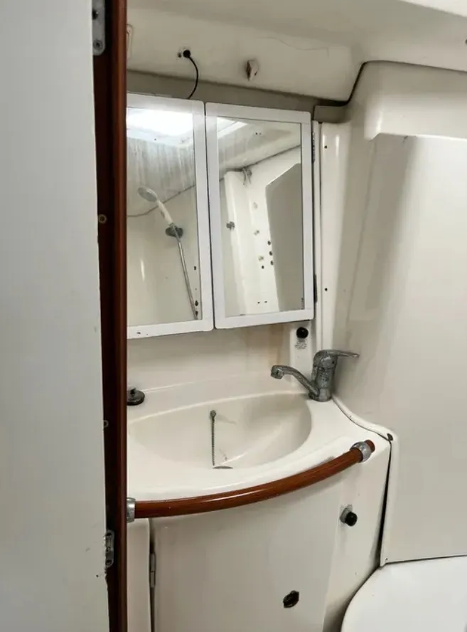 Slide: The Image of The image shows a boat bathroom with a sink, mirror, and faucet. - 6