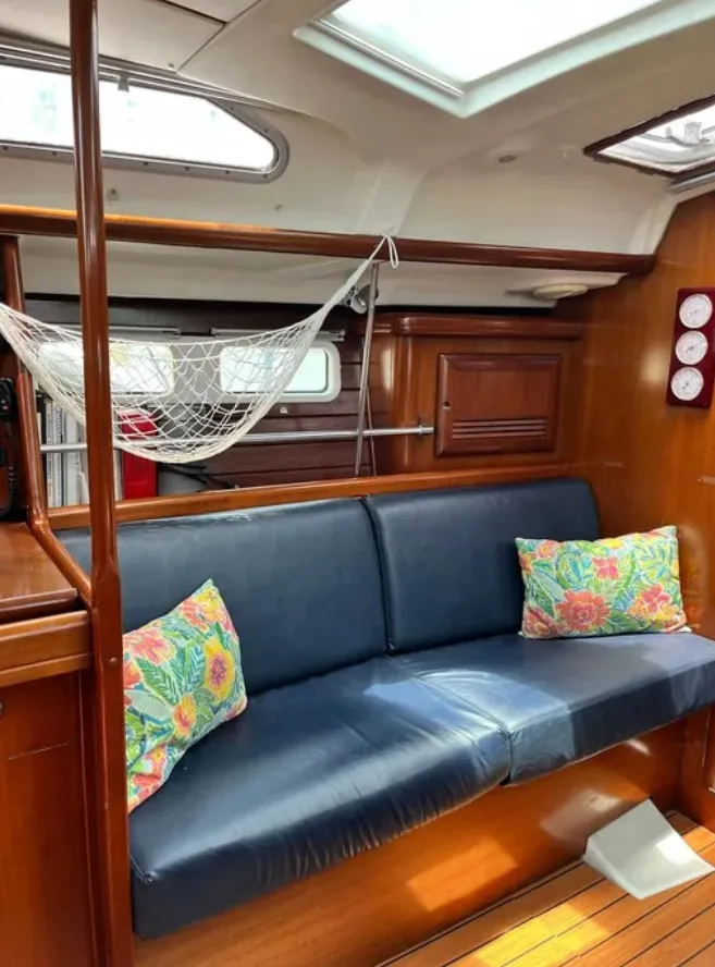 Slide: The Image of Interior of a 2005 Beneteau 423 with a blue sofa and colorful pillows. - 12