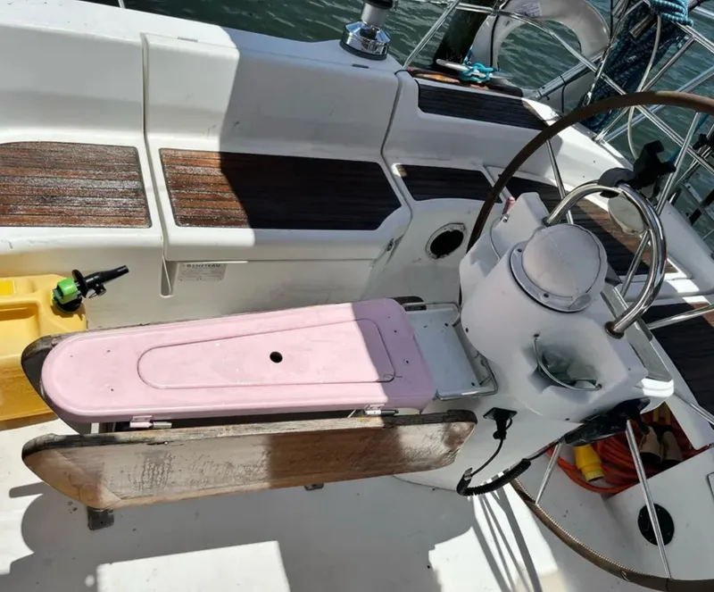 Slide: The Image of The cockpit of a 2005 Beneteau 423 with a steering wheel and wooden flooring. - 2