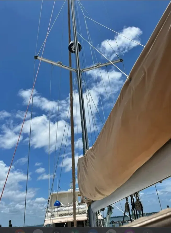 Slide: The Image of The 2005 Beneteau 423 features its mast and sail under a clear blue sky. - 1