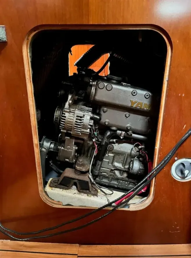 Slide: The Image of An engine compartment with a Yanmar engine inside a wooden enclosure. - 16