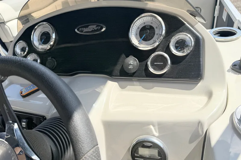 Slide: The Image of Dashboard of a 2018 Starcraft Cruise 220 boat with gauges and controls. - 16