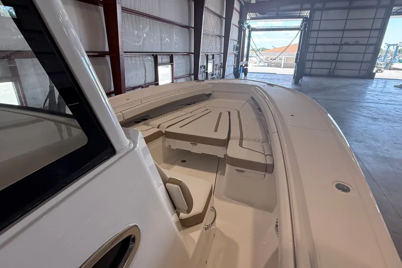 Slide: The Image of 2027 Regulator 31 boat interior with cushioned seating in a spacious warehouse. - 5