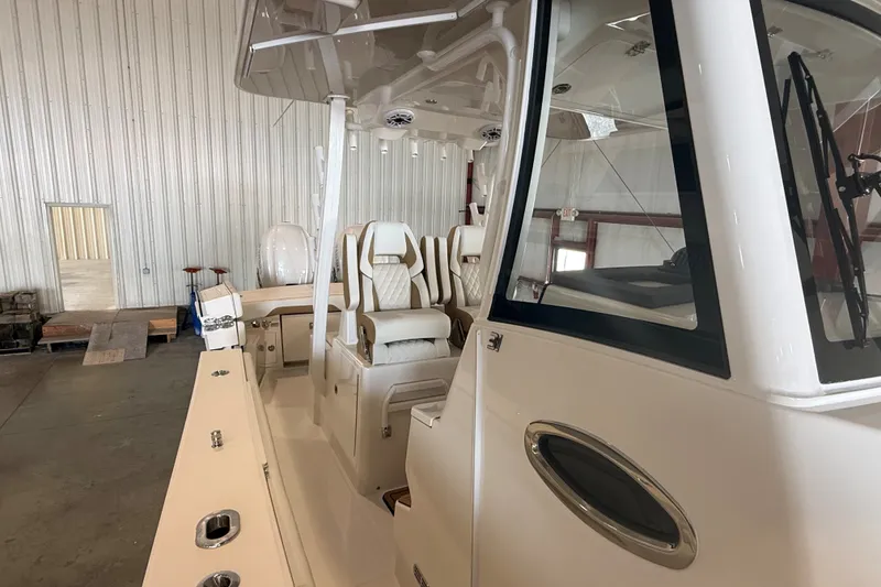 Slide: The Image of 2027 Regulator 31 boat interior with luxurious seating in a spacious warehouse. - 6