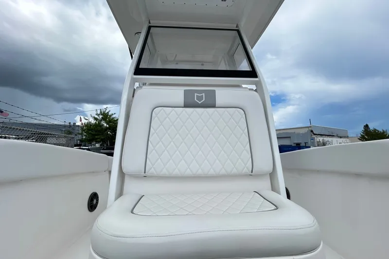 Slide: The Image of 2025 Sea Fox 228 Commander boat seat with quilted white upholstery under cloudy sky. - 6
