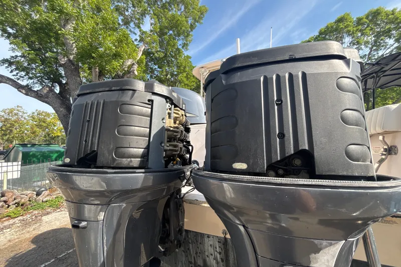 Slide: The Image of Twin outboard motors on a 2008 Grady-White Freedom 275 boat, surrounded by trees. - 18
