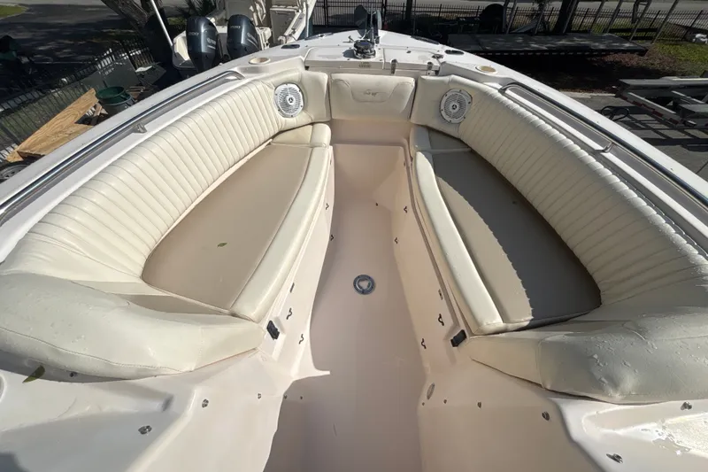 Slide: The Image of 2008 Grady-White Freedom 275 boat interior with white cushioned seating and speakers. - 13