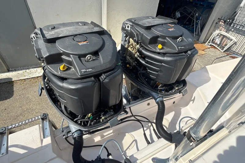 Slide: The Image of Twin outboard engines on a 2008 Grady-White Freedom 275 boat, docked outdoors. - 21