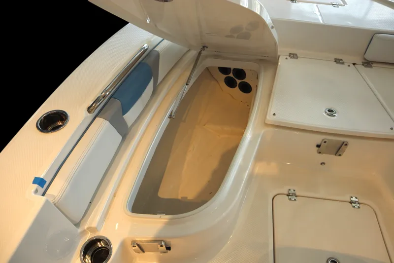 Slide: The Image of 2026 Robalo 226 Cayman boat interior storage compartment with open hatch and seating area. - 7