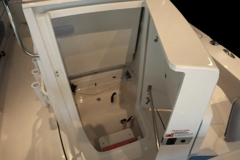 Slide: The Image of 2026 Robalo 226 Cayman boat storage compartment with open hatch and rod holders. - 13