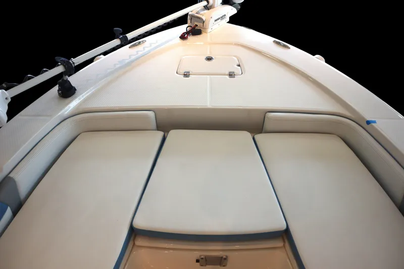 Slide: The Image of 2026 Robalo 226 Cayman boat interior with cushioned seating and storage compartment. - 4
