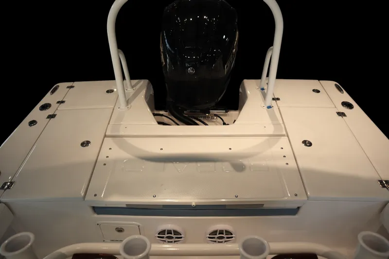 Slide: The Image of 2026 Robalo 226 Cayman boat deck with motor, featuring sleek design and storage compartments. - 25