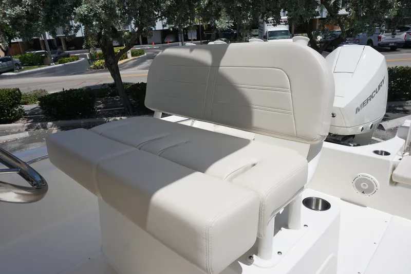 Slide: The Image of 2027 Boston Whaler 210 Montauk boat seat with white upholstery and Mercury engine in background. - 18