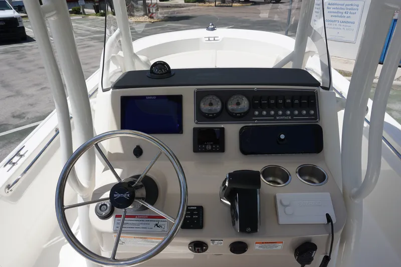 Slide: The Image of 2027 Boston Whaler 210 Montauk boat dashboard with steering wheel and controls. - 22