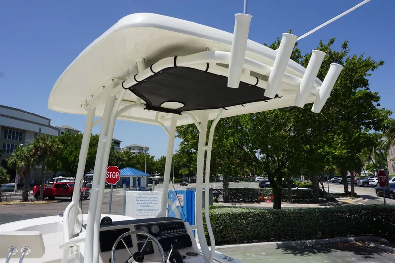 Slide: The Image of 2027 Boston Whaler 210 Montauk boat with T-top and rod holders, parked outdoors. - 24
