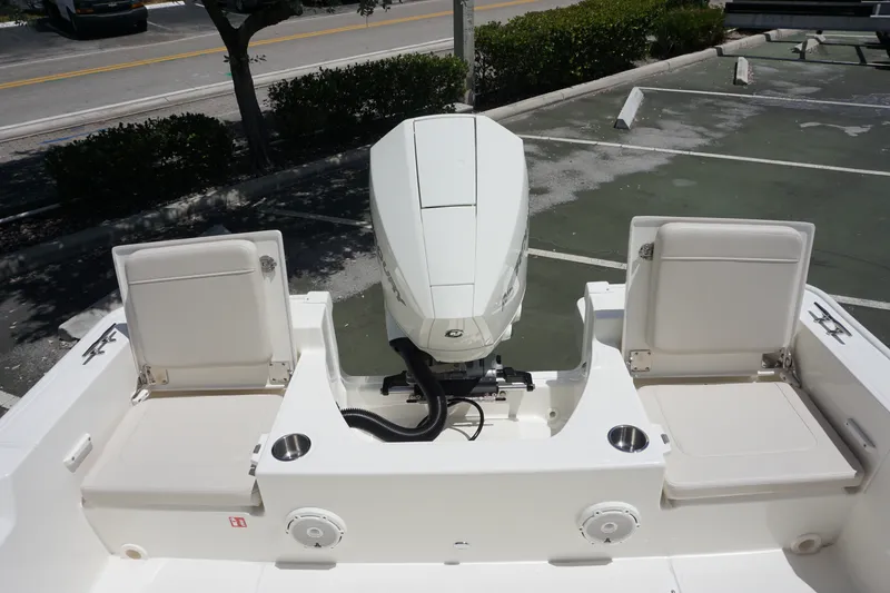 Slide: The Image of 2027 Boston Whaler 210 Montauk boat with dual seats and outboard motor in a parking lot. - 13