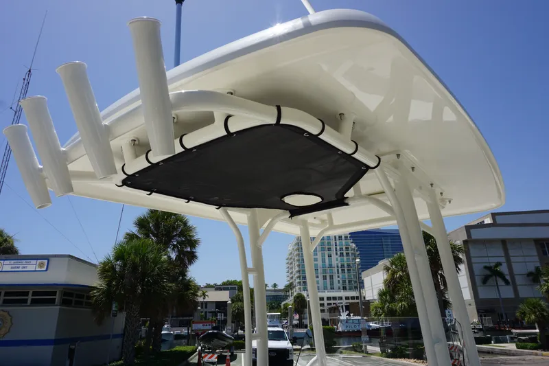Slide: The Image of Boston Whaler 210 Montauk 2027 boat canopy with rod holders, docked in sunny marina. - 23