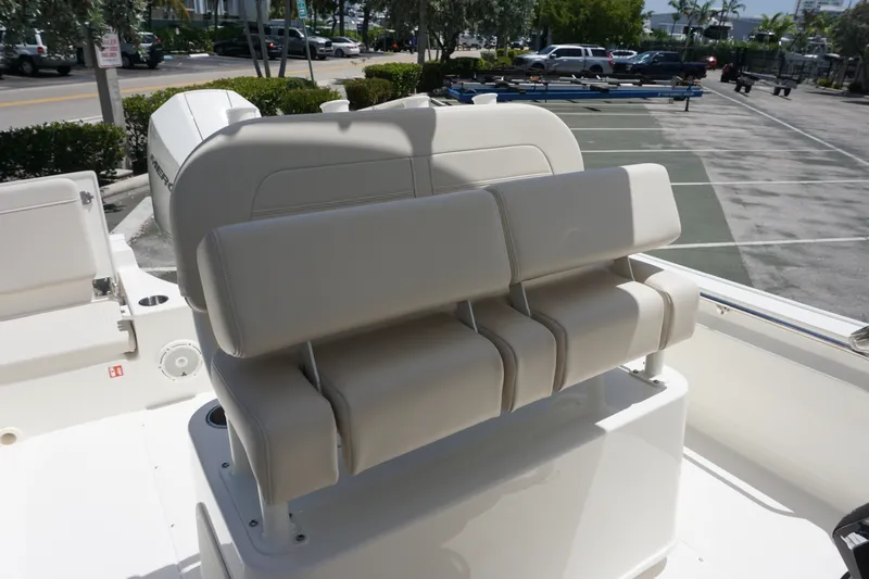Slide: The Image of 2027 Boston Whaler 210 Montauk boat seating, featuring beige cushioned seats and sleek design. - 16