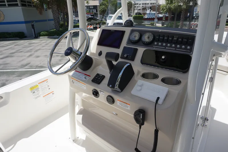 Slide: The Image of 2027 Boston Whaler 210 Montauk boat console with steering wheel and navigation controls. - 20