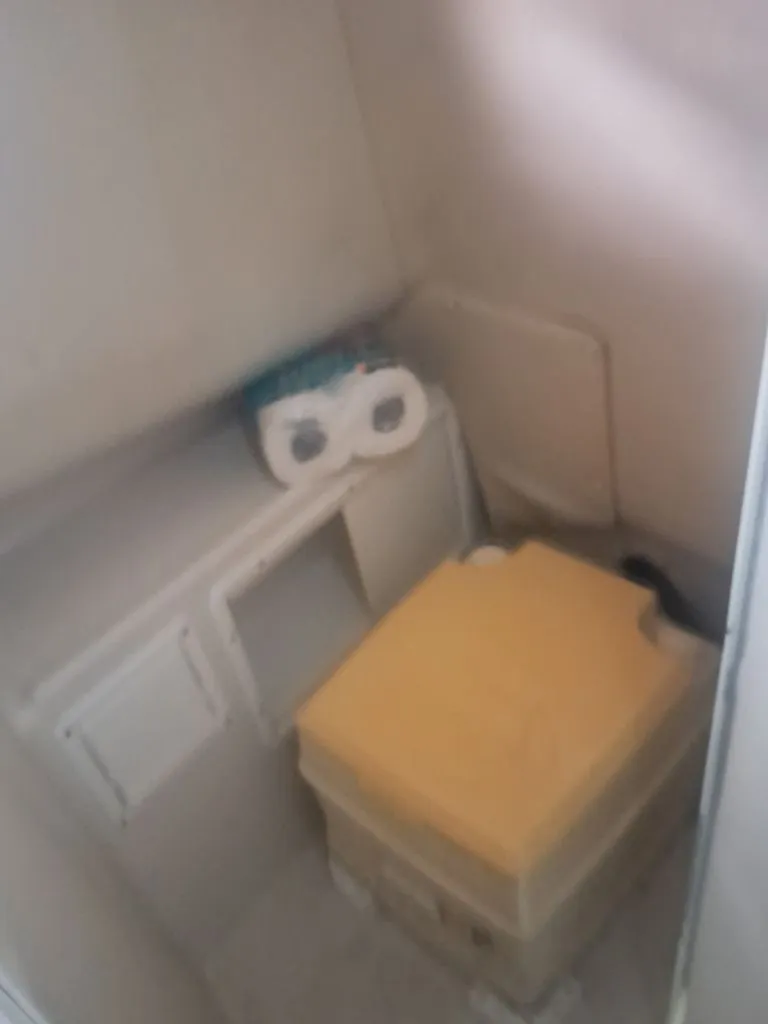 Slide: The Image of A small space with a yellow seat and a roll of toilet paper. - 8