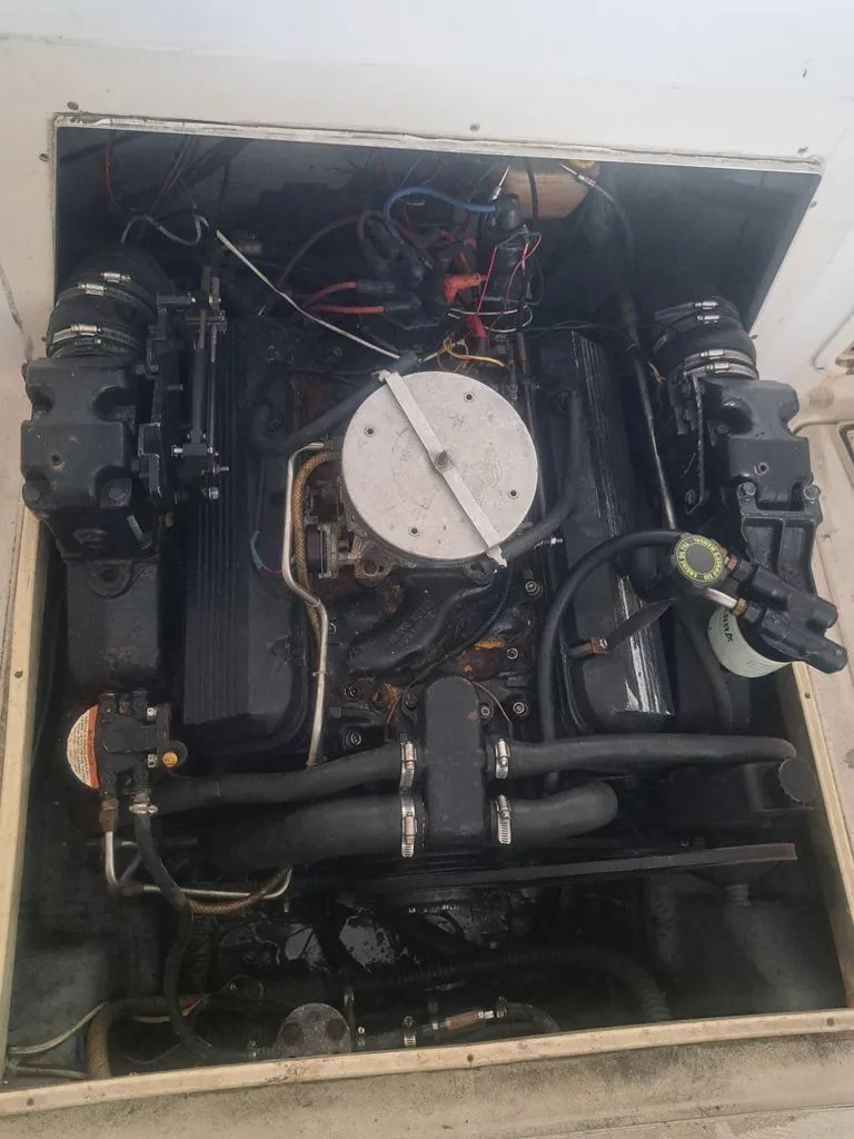 Slide: The Image of An engine compartment with a large engine, surrounded by wires and hoses, inside a boat. - 11
