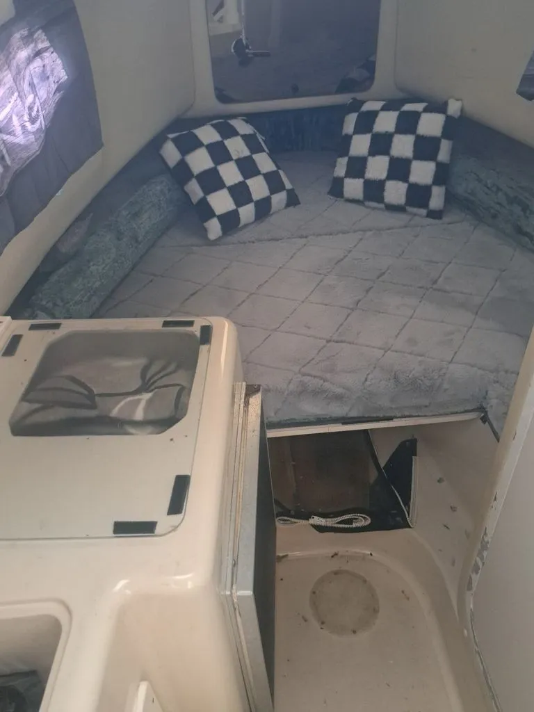 Slide: The Image of The image shows the interior of a boat with a cozy sleeping area and checkered pillows. - 7