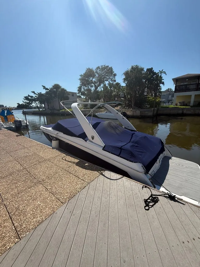 Slide: The Image of A 2018 Regal 26 FasDeck boat docked in sunny weather, featuring a blue cover. - 3