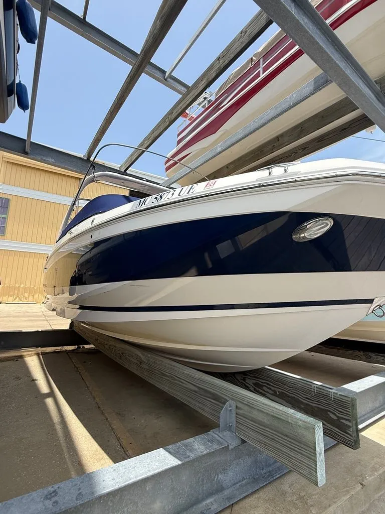 Slide: The Image of A 2018 Regal 26 FasDeck is on a boat stand in a storage area. - 8
