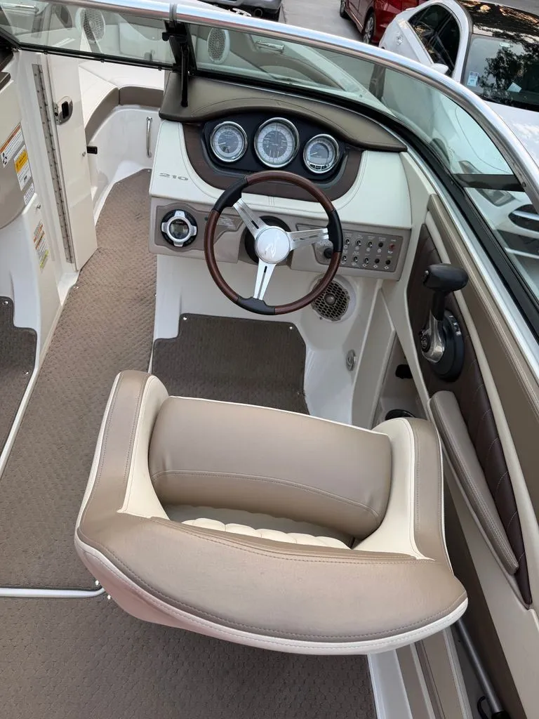 Slide: The Image of The image shows the cockpit of a 2013 Sea Ray 210 SLX with a sleek steering wheel and dashboard. - 5