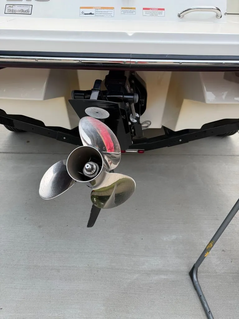 Slide: The Image of A 2013 Sea Ray 210 SLX with a shiny propeller, positioned on a concrete floor. - 22