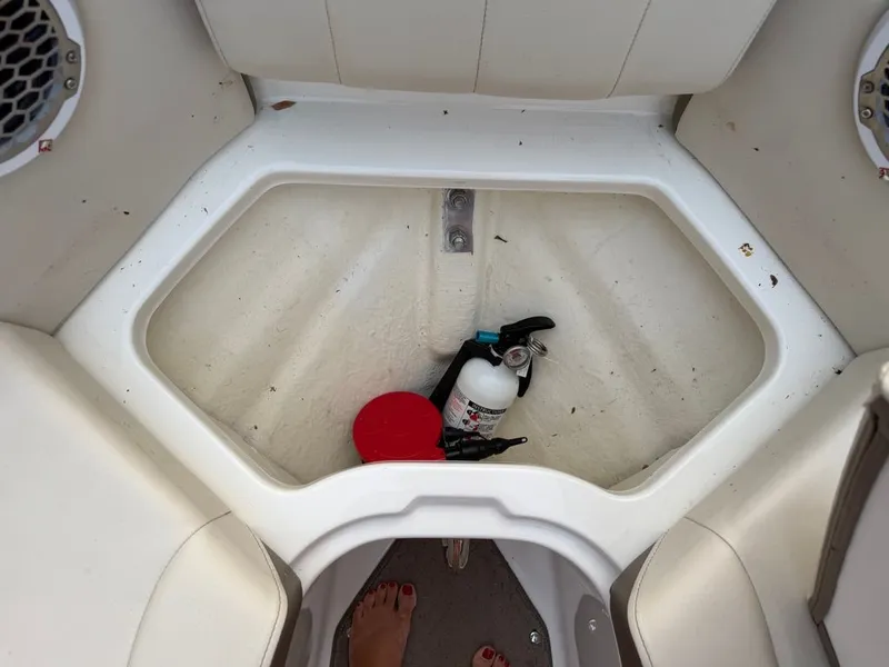 Slide: The Image of A storage compartment in the bow of a Sea Ray 210 SLX with a fire extinguisher and other items. - 11