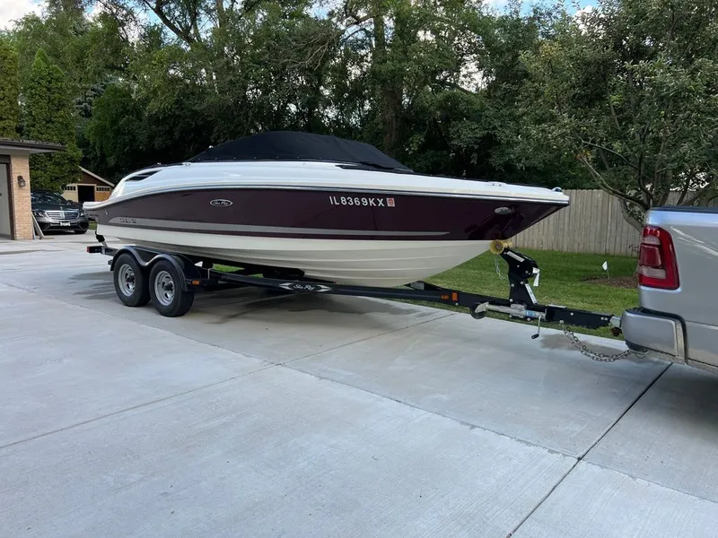 Slide: The Image of A 2013 Sea Ray 210 SLX on a trailer, parked in a driveway next to a pickup truck. - 29