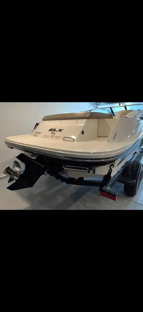 Slide: The Image of The image shows the rear of a 2013 Sea Ray 210 SLX boat with an outboard motor. - 2