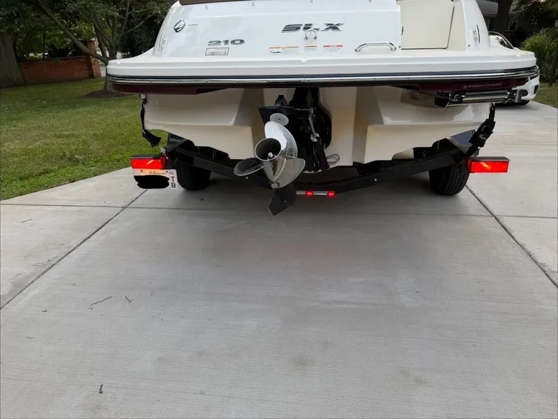 Slide: The Image of The image shows the rear of a white Sea Ray 210 SLX boat on a trailer. - 28