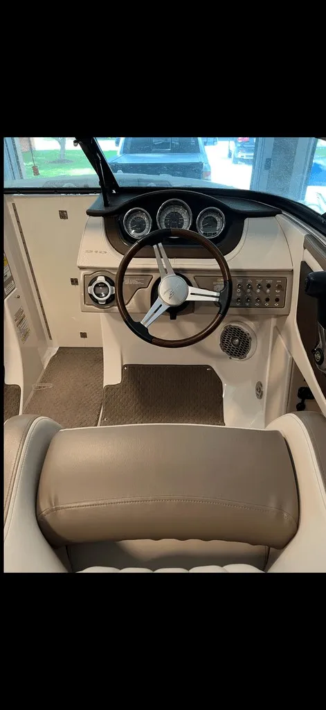 Slide: The Image of The image shows the cockpit of a 2013 Sea Ray 210 SLX with a sleek steering wheel and dashboard. - 4