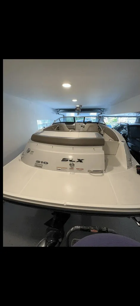 Slide: The Image of A 2013 Sea Ray 210 SLX boat in a garage. It features a sleek, modern design. - 16