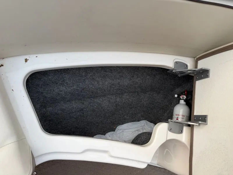 Slide: The Image of Interior of a Sea Ray 210 SLX boat with a fire extinguisher and carpeted floor. - 12