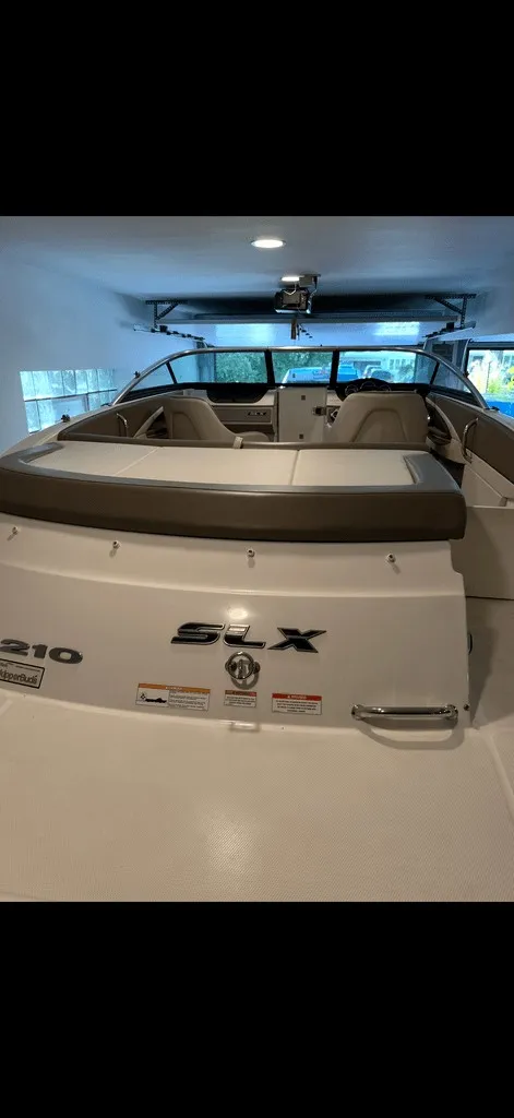 Slide: The Image of The image shows a 2013 Sea Ray 210 SLX boat in a garage. - 17
