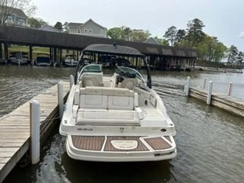 Slide: The Image of A 2013 Sea Ray 260 Sundeck docked. It features spacious seating and a canopy. - 2