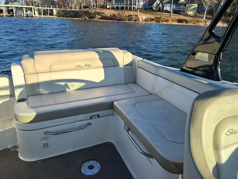 Slide: The Image of The 2013 Sea Ray 260 Sundeck features a spacious, cushioned seating area overlooking the water. - 8