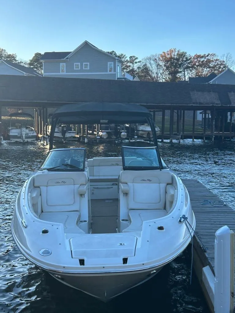 Slide: The Image of 2013 Sea Ray 260 Sundeck at dock, featuring open cockpit and bimini top. - 3