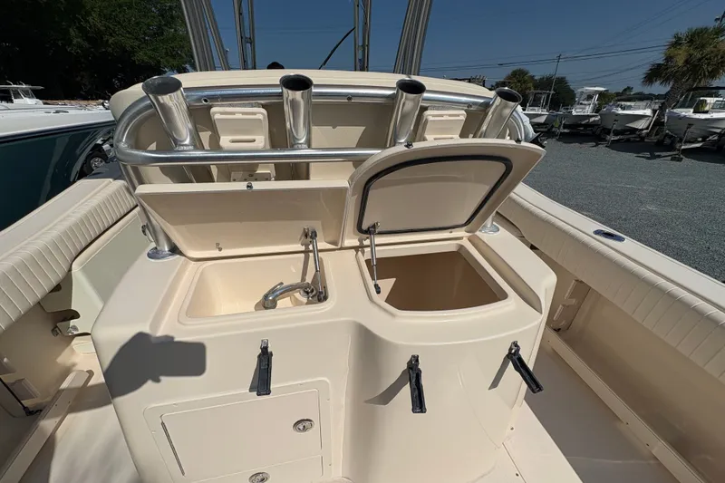 Slide: The Image of 2011 Grady-White Canyon 283 boat interior with open storage compartments and rod holders. - 23