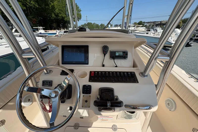 Slide: The Image of 2011 Grady-White Canyon 283 boat dashboard with steering wheel and electronic controls. - 19