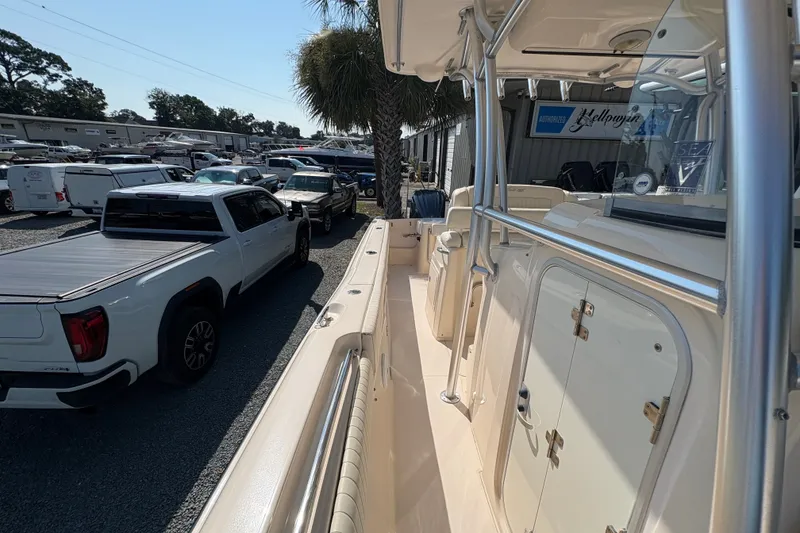 Slide: The Image of 2011 Grady-White Canyon 283 boat parked near trucks at a dealership. - 13