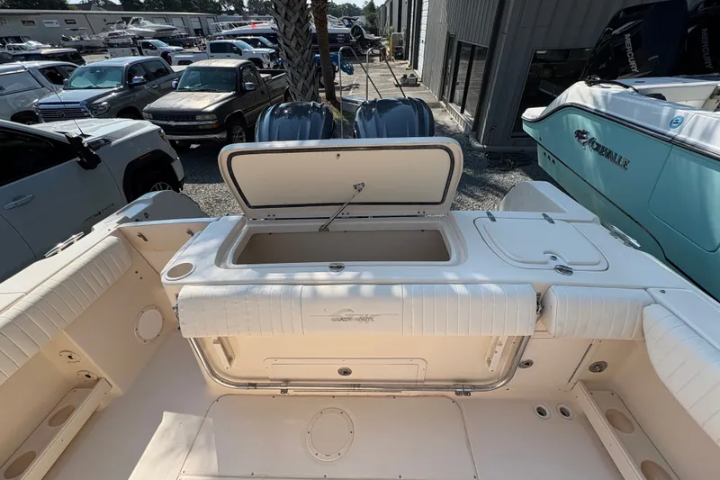 Slide: The Image of 2011 Grady-White Canyon 283 boat interior with open storage compartment, surrounded by vehicles. - 25