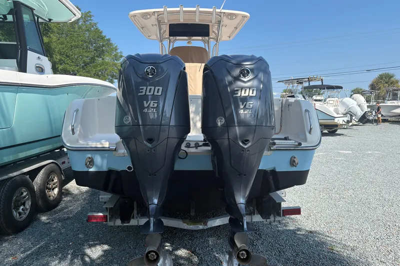 Slide: The Image of 2011 Grady-White Canyon 283 boat with dual 300 V6 4.2L engines, parked outdoors. - 2