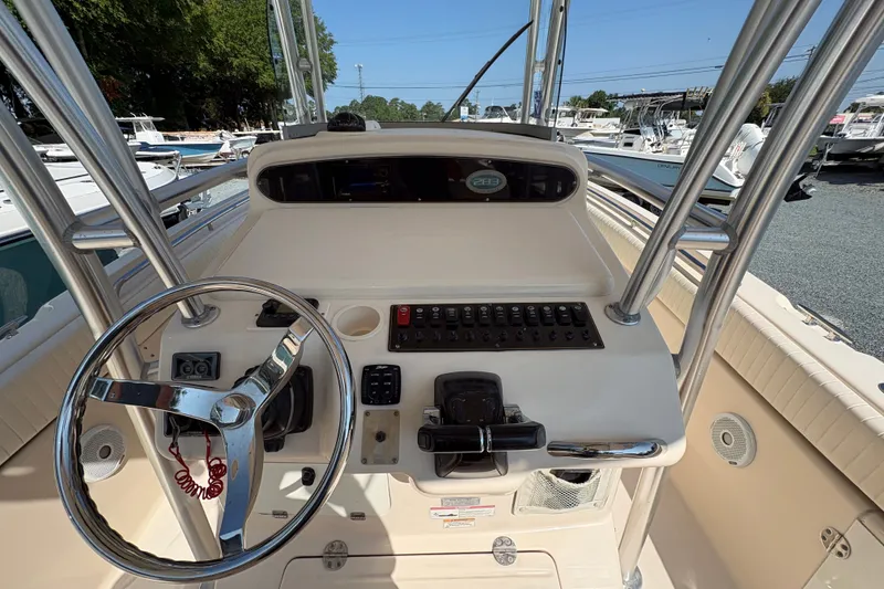 Slide: The Image of 2011 Grady-White Canyon 283 boat dashboard with steering wheel and control panel. - 18