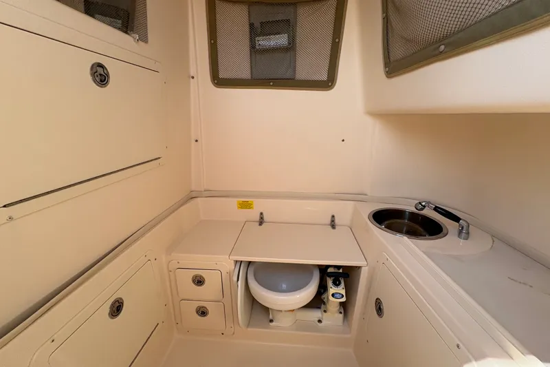 Slide: The Image of 2011 Grady-White Canyon 283 boat interior with compact bathroom and sink. - 14